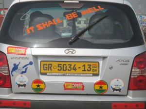 A car with "it shall be well" posted on its rear window.