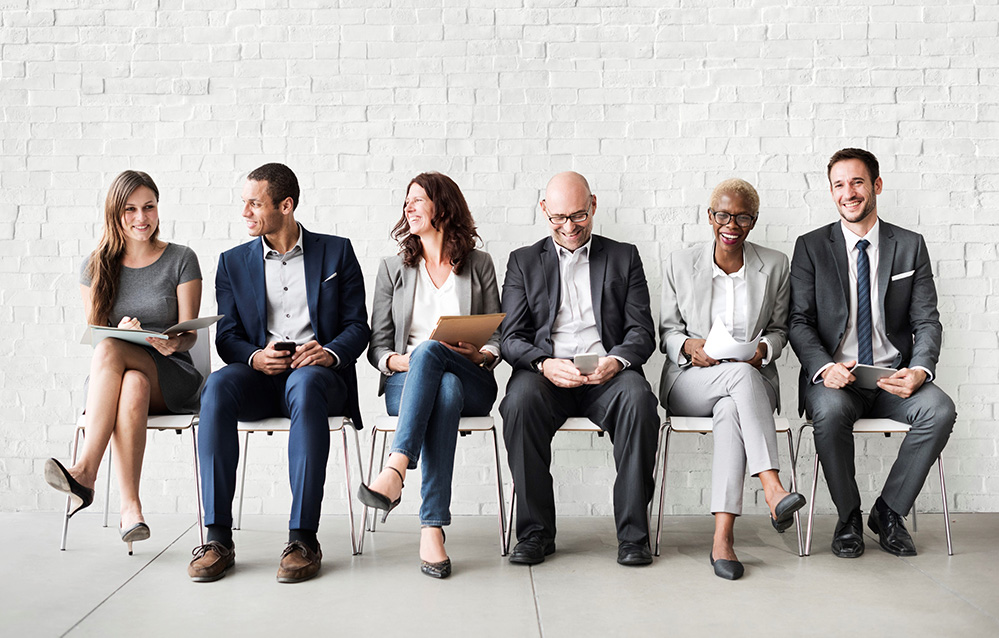 Diverse group of business people sitting on chairs and laughing