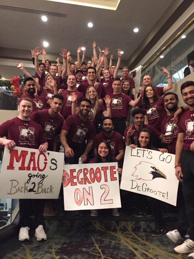 DeGroote students holding signs showing McMaster pride