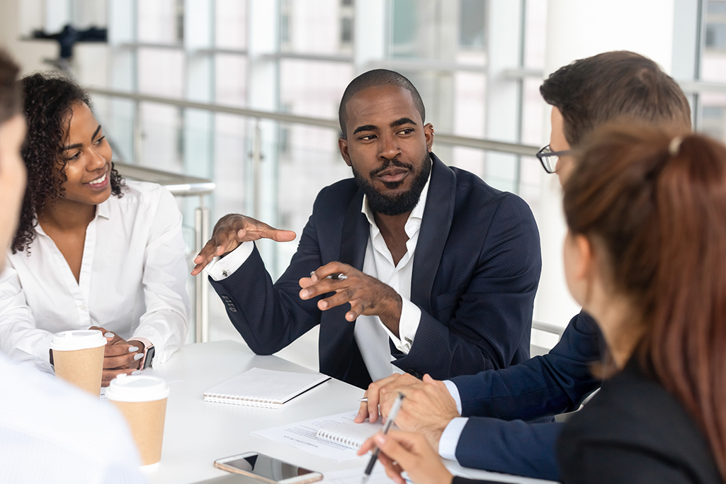 Millennial boss leading corporate team during briefing in boardroom