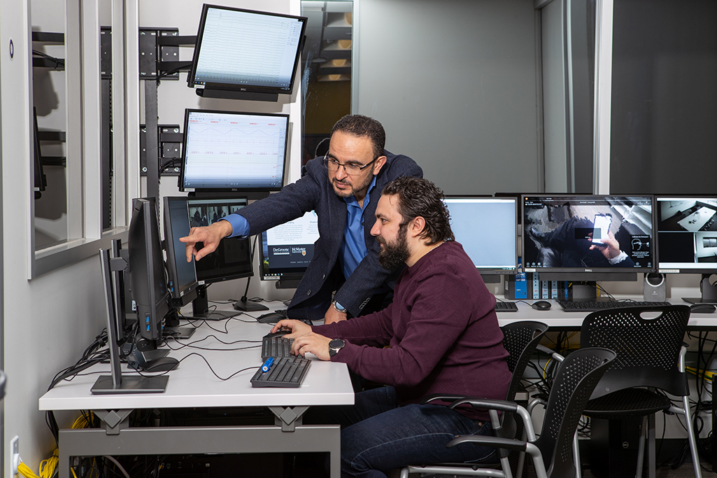 Khaled Hassanein showing Nour El Shamy something on computer screens