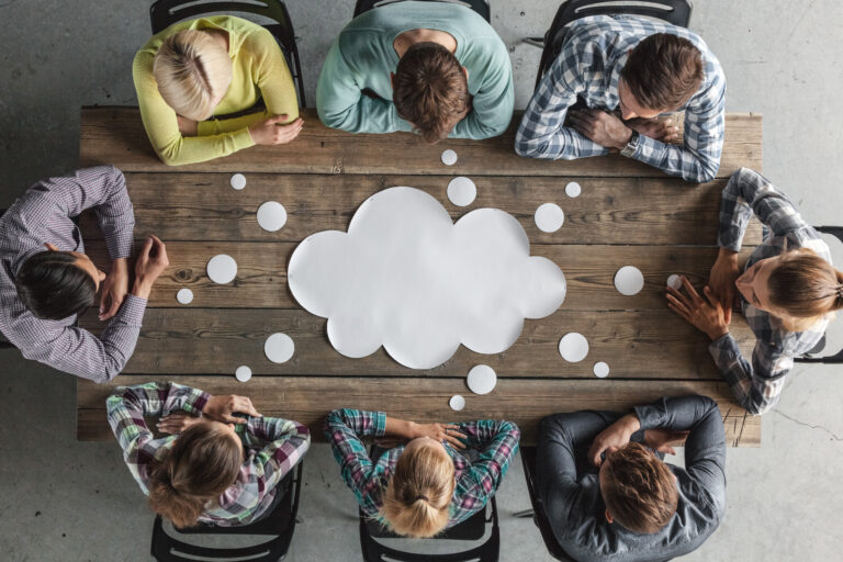 Idea bubble on wood table with people gathered around it