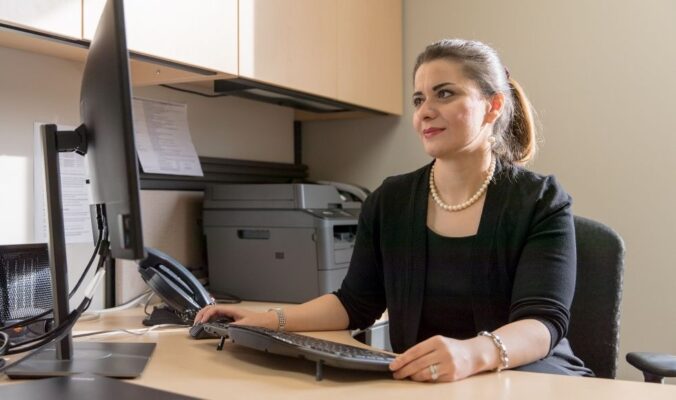 Professor Maryam Ghasemaghaei sitting at a desk analyzing data