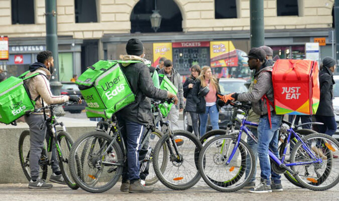 Food delivery couriers (gig workers) congregate in Turin, Italy. (Shutterstock)