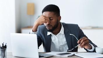 Businessman massaging his nose bridge, tired of work and struggling mental health