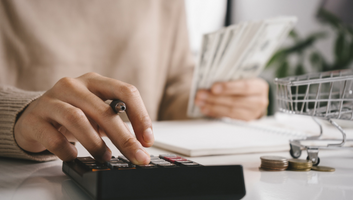 Woman counting and calculating budgets on a calculator due to rising inflation rates