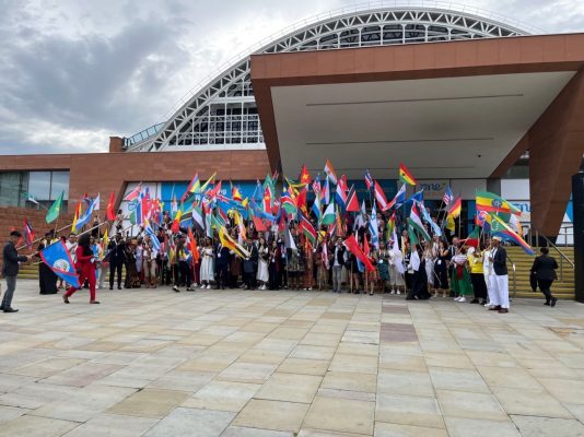 Delegates from around the world waving their country's flag.