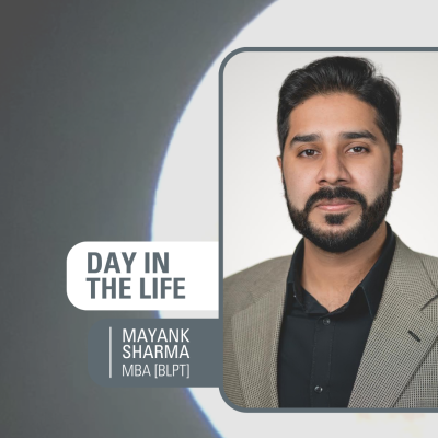 Male student, Mayank Sharma, with short brown hair, brown eyes, and a beard looking into the camera, smiling, on a background of a photo of the moon. Includes text "Day in the Life - Mayank Sharma, BLPT MBA"