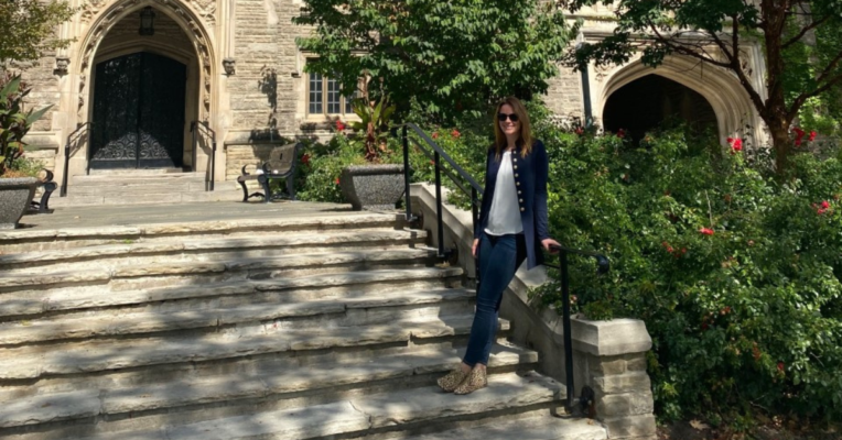 Lindsay Hampson (EMBA '22), founder of ThisRock, a consulting firm focused on saving the planet and adopting sustainability practices, standing on the staircase in front of a building on the McMaster University campus.