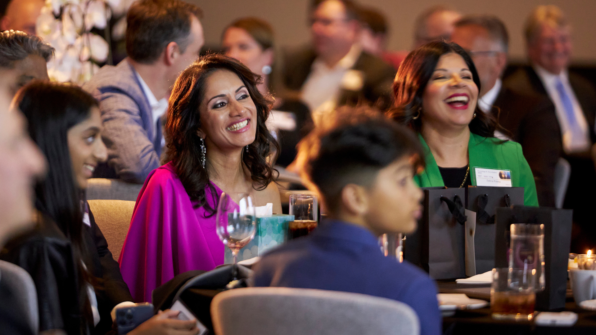 Award winner sitting at table smiling.