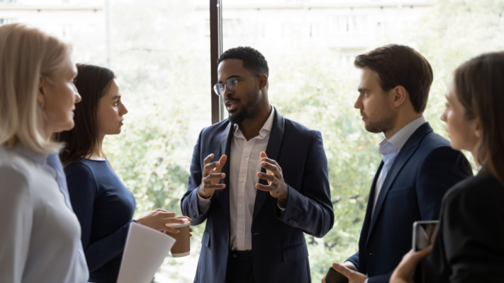 Executive leader of a company discussing leadership turnover with employees and how it affects customer relations