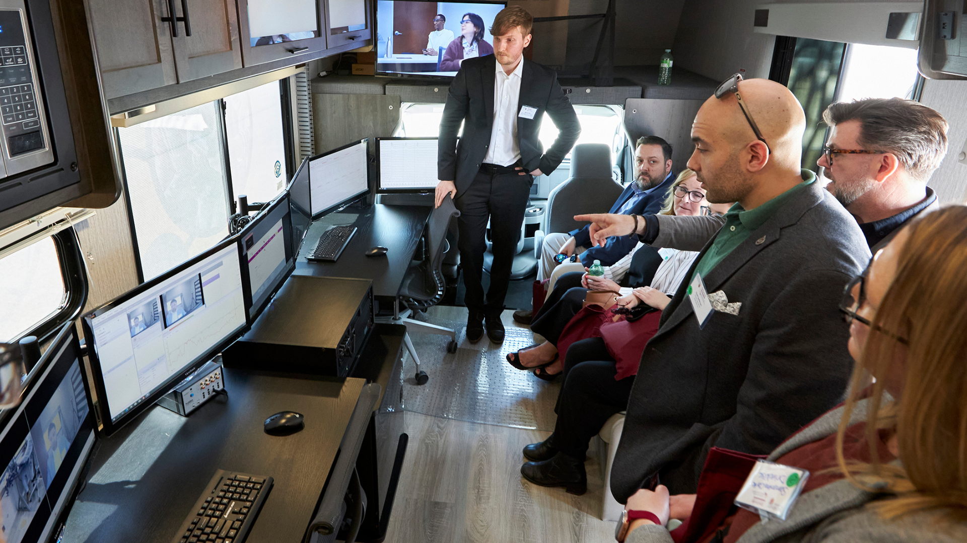 MDTRC Research Assistant shows tour participants how the neurophysiological tools in the new mobile lab work