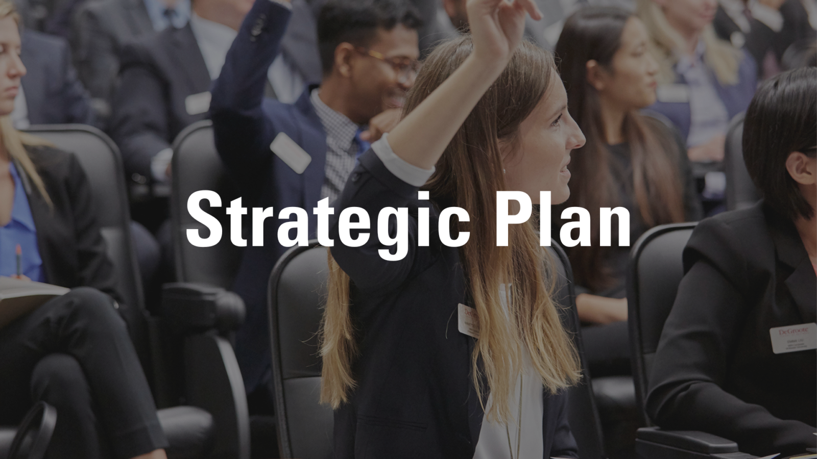 Strategic Plan Hero Image that has the text "Strategic Plan". The image behind is a DeGroote student raising her hand to ask a question.
