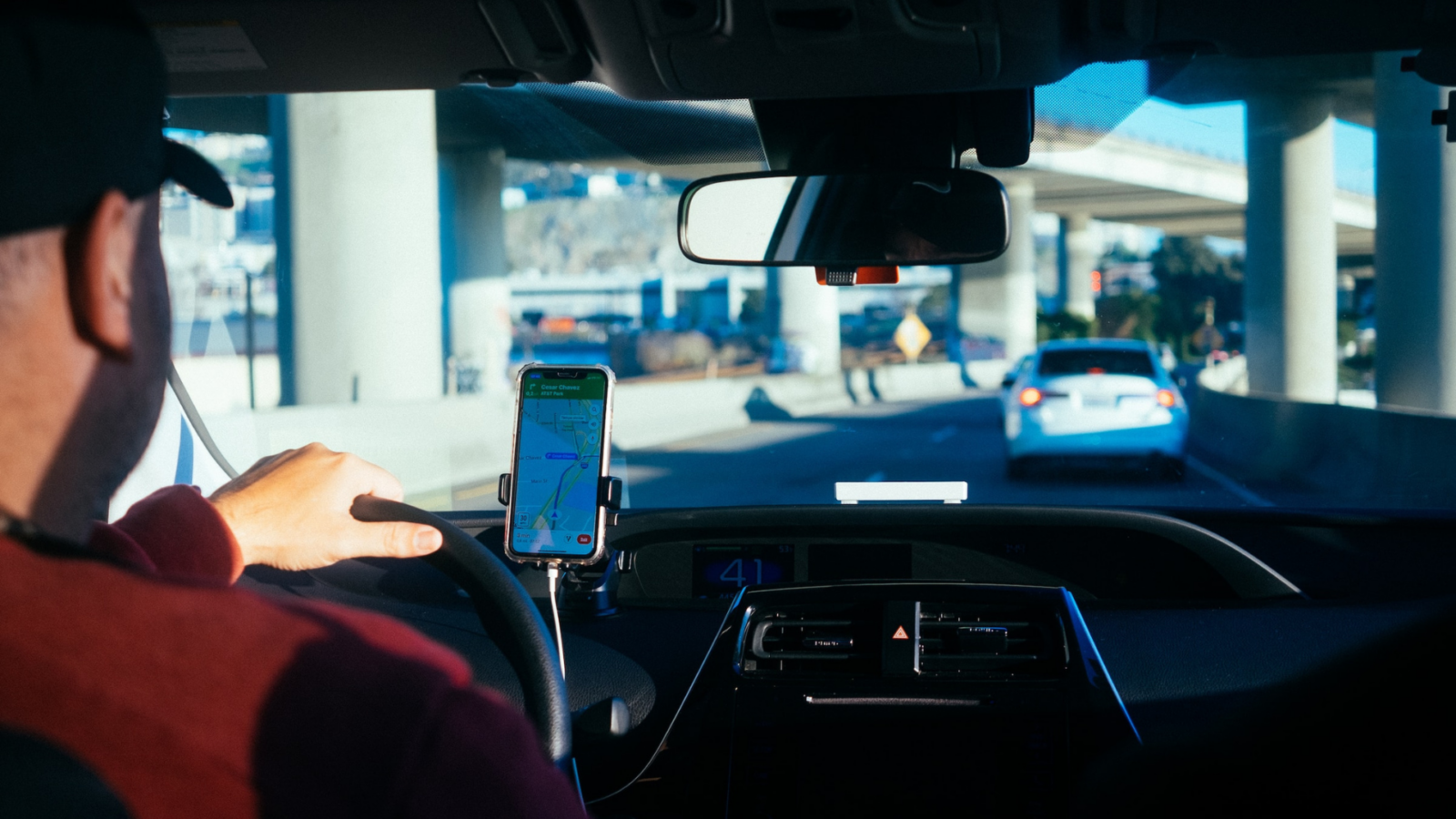 Taxi driver following directions on his phone GPS.