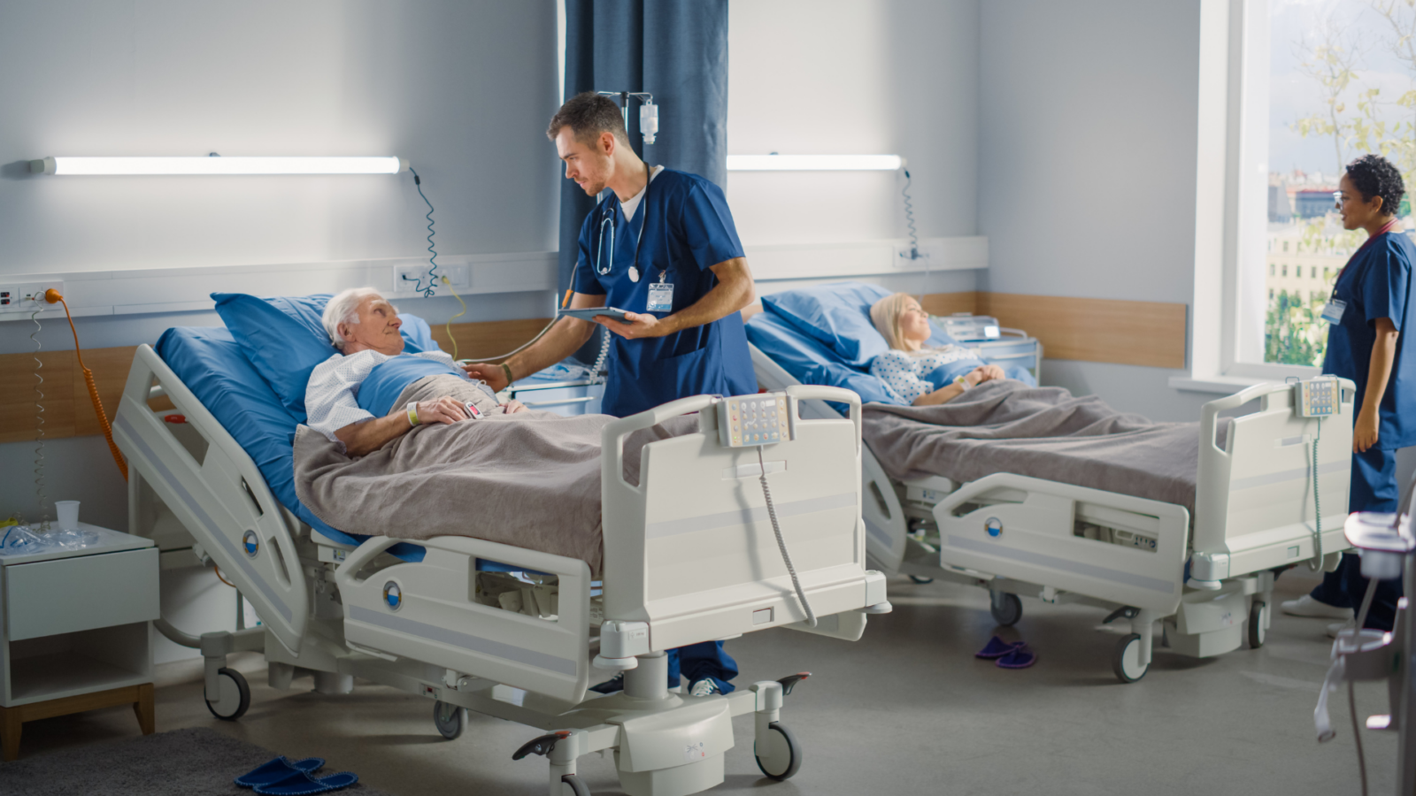 Doctor speaking with an elderly patient in a hospital bed.